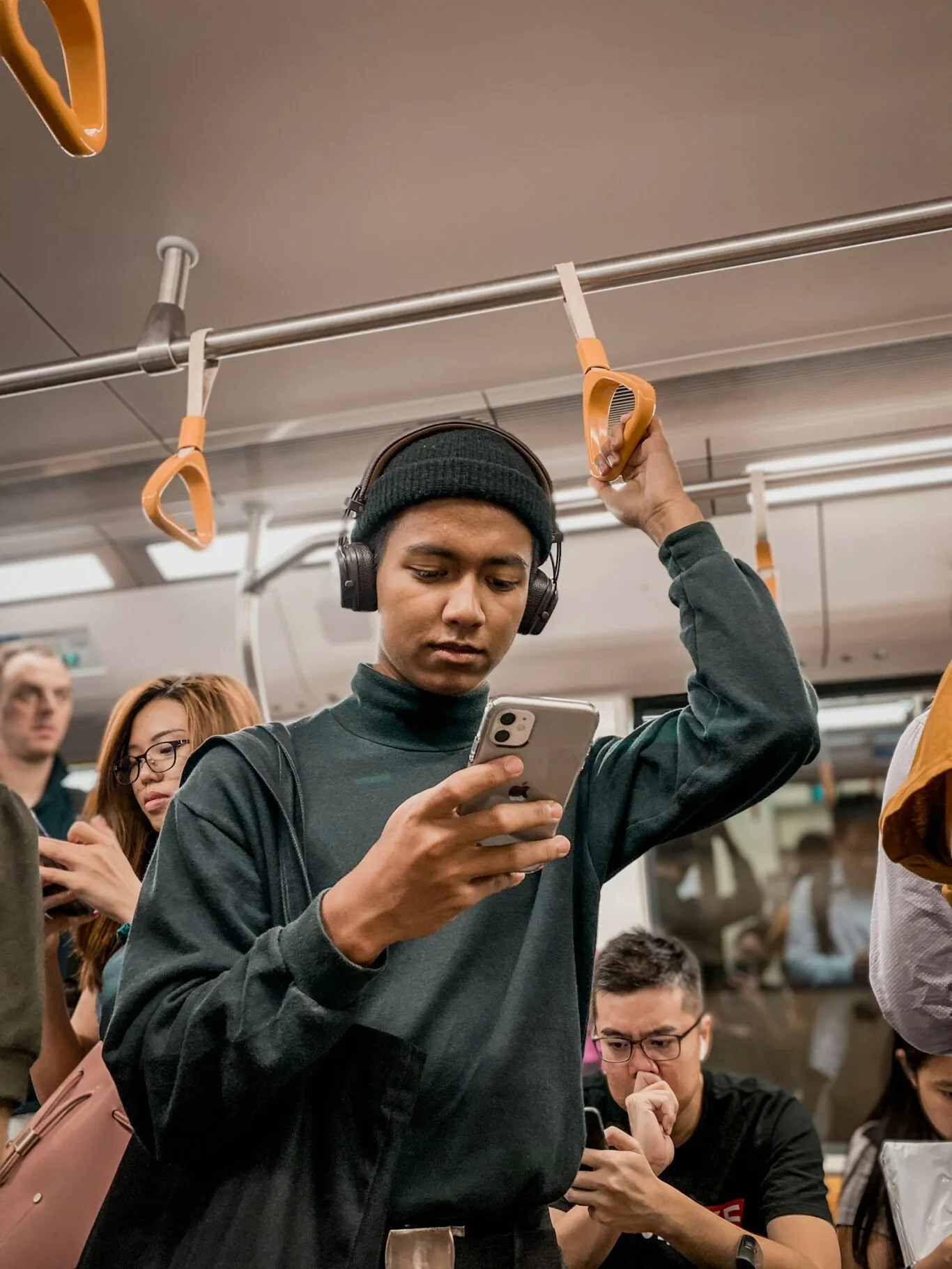 Person st&aring;r p&aring; tunnelbanan och kollar i sin mobil
